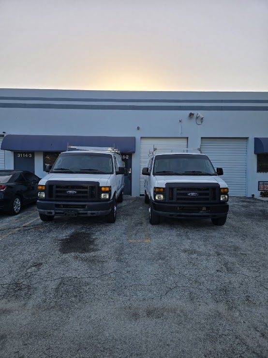 Sunshine Auto Hub storefront and work vans in West Palm Beach, Florida